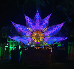 a stage with a large colorful flower in the background