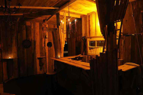 a wooden room with candles hanging from the ceiling