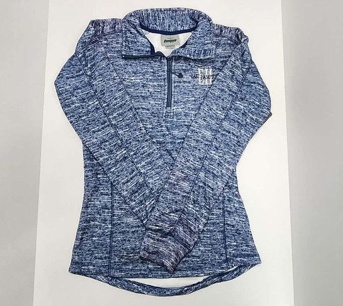 Blue quarter zip-up sweatshirt, text on front- East Hampton, laid flat on white surface. Clothing.