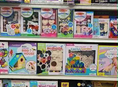 shelved stocked with arts and crafts kits including painting kits of magnets, birdhouses and ceramic figures
