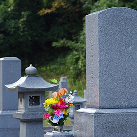 灯籠とお花が供えられた墓石