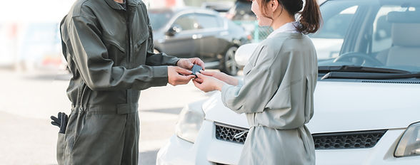 お客様の車のキーを渡す整備士