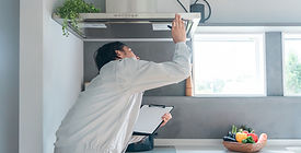 換気ダクトの点検をしている作業服の男性