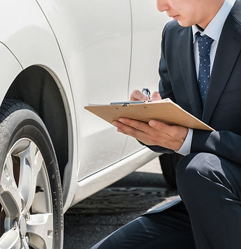 車の横にかがんでタイヤのチェックをする男性