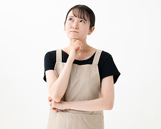 困った様子のエプロンをつけた女性