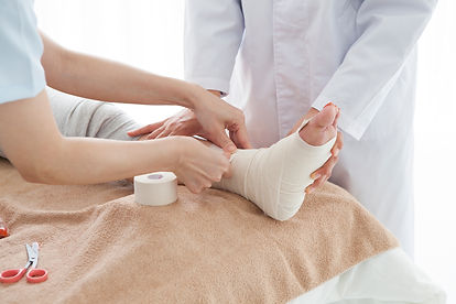 捻挫をした足にテーピングする医師の手元