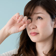 かゆい目をこする女性