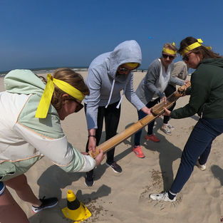 Collega’s werken samen tijdens Expeditie Robinson teambuilding aan zee in De Panne