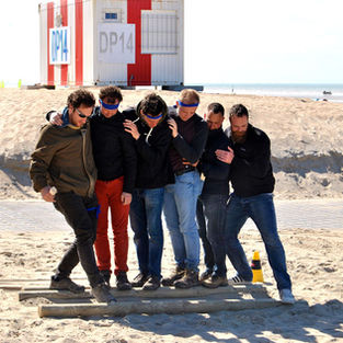 Groepen nemen het tegen elkaar op tijdens Expeditie Robinson op het strand van De Panne, een actieve groepsactiviteit aan zee bij StevoKitesurf.