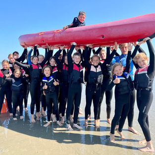 Groep kinderen beleeft strandactiviteiten tijdens het Surf & Beach kamp in De Panne