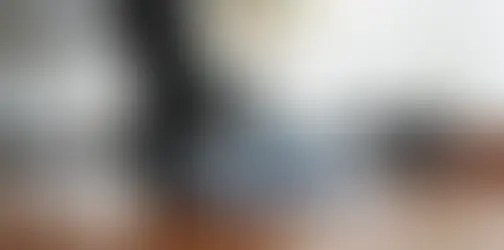 Person vacuuming hardwood floor in a living room