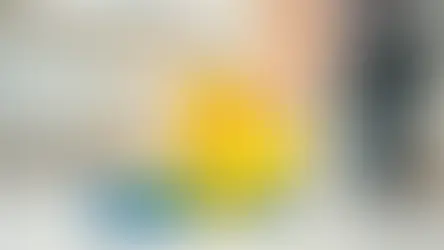 Person wearing gloves cleaning a tile floor with a cloth.