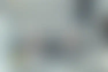 Two cleaners in protective suits vacuuming a modern living room