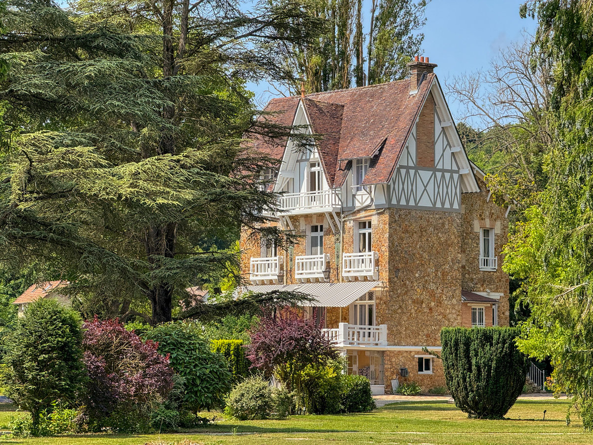 La façade en pierre du Manoir des 3 Cèdres entourée de cèdres centenaires