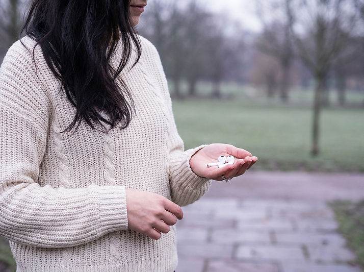 Woman listening to the Overachiever Recovery podcast outdoors, a show for overachievers recovering from burnout and people-pleasing