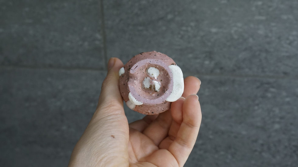 Thumbnail: Pink ceramic Japanese sake cup with white drippy glaze bottom view