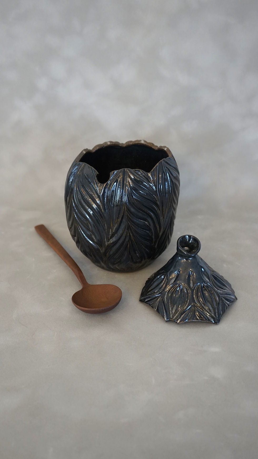 Thumbnail: Hand-carved sugar pot with glittery black glaze and a spoon