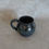 Thumbnail: black clay globe mug with a sparkly black glaze top view