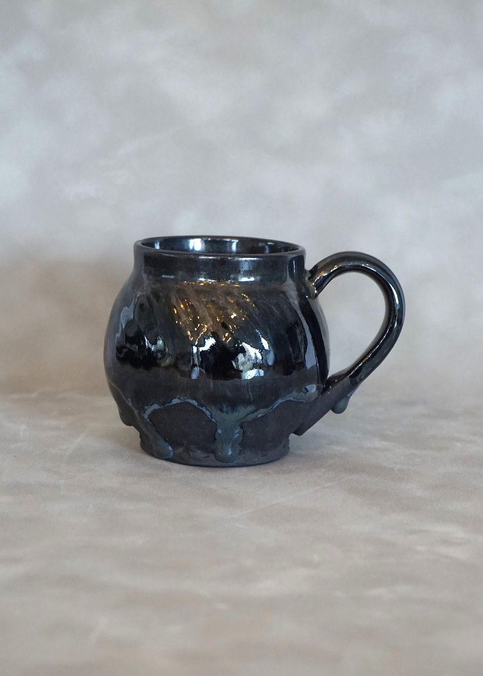 Thumbnail: black clay globe mug with a sparkly black glaze side view