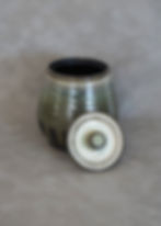 Black clay ceramic jar with a green and white glaze