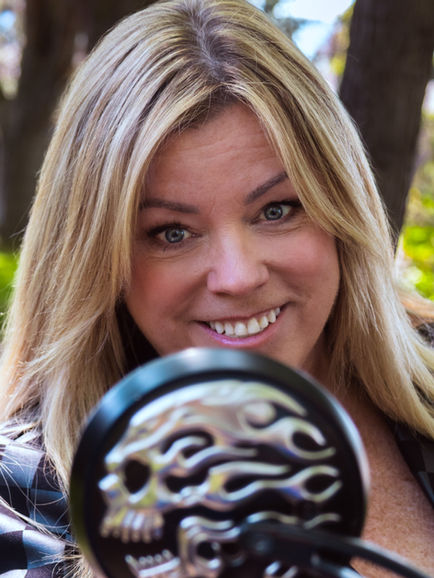 a woman is smiling while holding a black object with flames on it