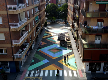 Vista general de la calle transformada por EZKA en un espacio peatonal con mural de pavimento en Laudio.