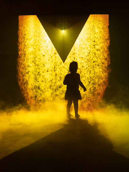 Silueta frente a un umbral de luz y niebla en LABEKO ATEA, instalación inspirada en el patrimonio industrial.