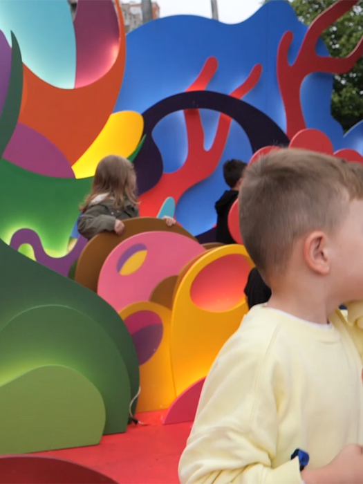 Niño jugando entre las formas de colores de la instalación lúdica POP-UP.