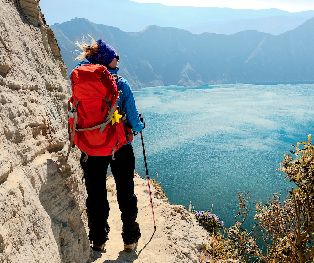 woman enjoying a spectacular view of a lake high in the mountains