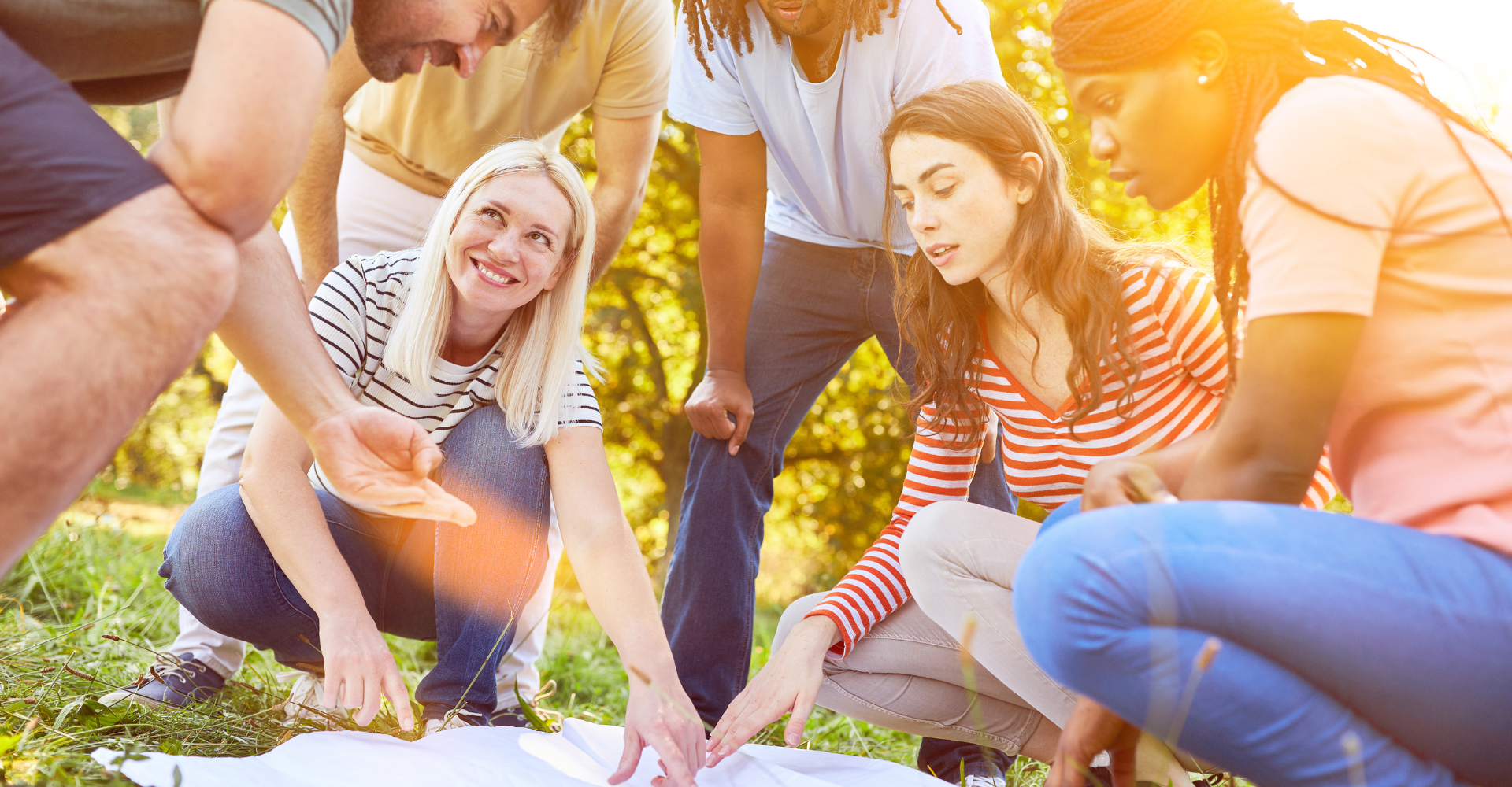 group of employees gathered around during an outdoor team building activity