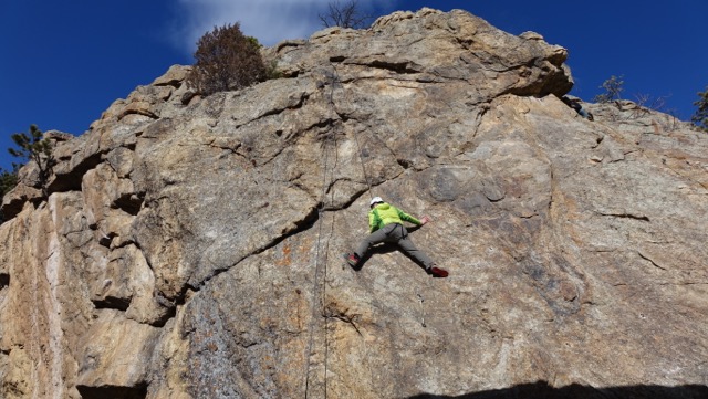 person top rope climbing a rock formation