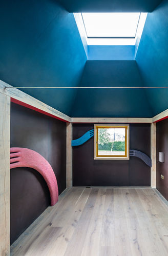 Bespoke oak carpentry featuring skylight and sculpted wall panels in a modern handcrafted room design.