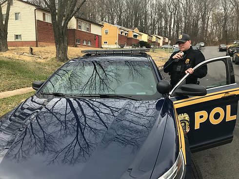COPS STANDING OUTSIDE CRUISER SPEAKING INTO RADIO MIC