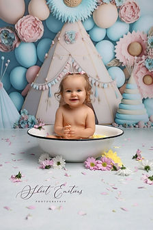 Bébé souriant dans un bain fleuri, décor pastel rose et bleu – séance photo bébé Shoot’Emotions dans l’Yonne