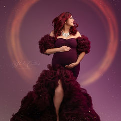 Femme enceinte en robe bordeaux pour shooting grossesse, cercle lumineux.