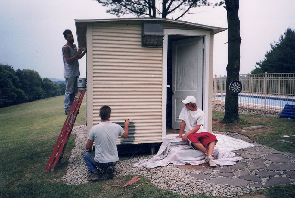 John and Derek ghrist painting and landscaping around their pool shed.