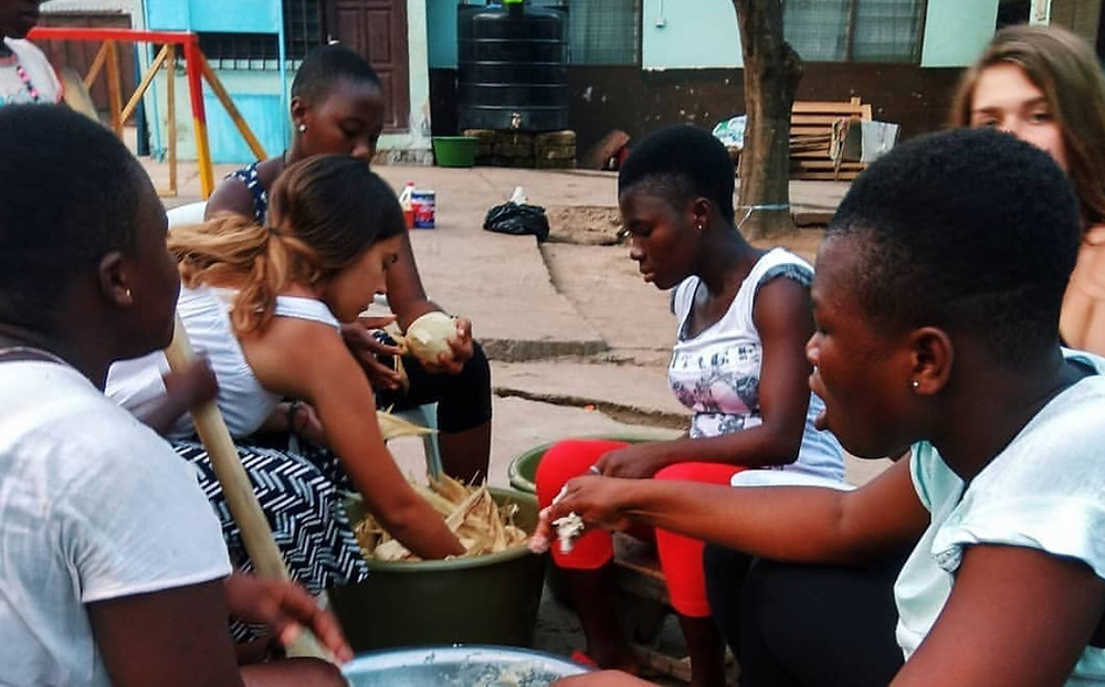 Kids with volunteers preparing kenkey