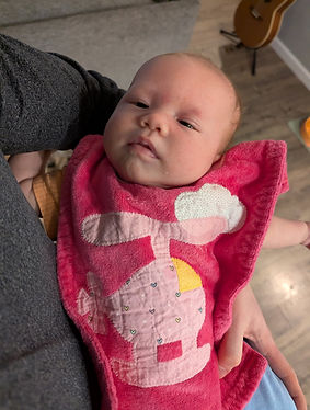 infant wearing bright pink bib with a pink helicopter