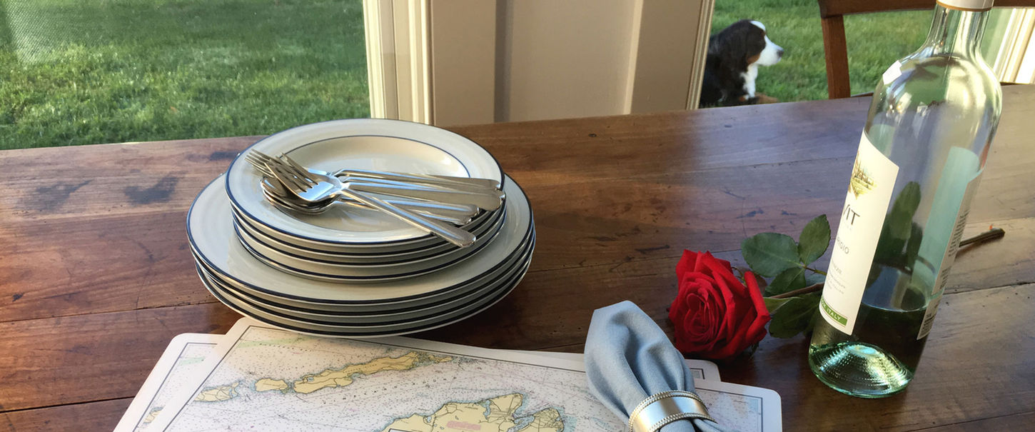 Pickering Company cork-backed hardboard placemats with Nautical Chart design on a table along with dishes and silver for setting the table