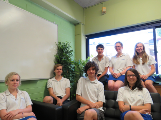 This image contains seven beautiful Colo High kids seated in a pleasant sunny classroom.