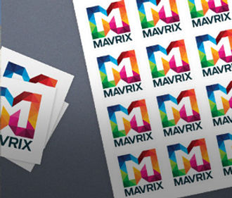Colorful sheets of "Mavrix" logos lie on a dark gray surface