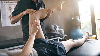 A physical therapist helps a person stretch their leg
