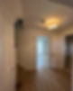 A hallway features light wood flooring