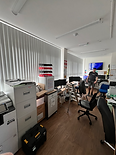 Modern office space with white vertical blinds on floor-to-ceiling windows