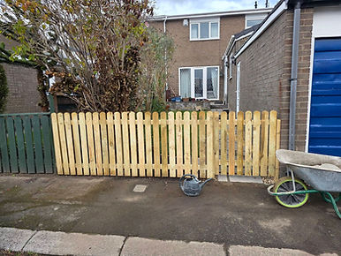 Newly installed light timber garden fencing panel setup standing on an outdoor concrete ground