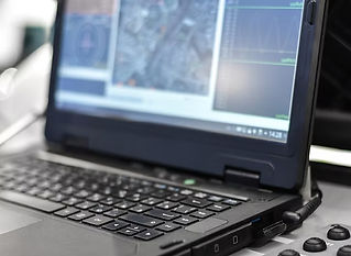 A laptop displaying blurred graphics and data charts on its screen