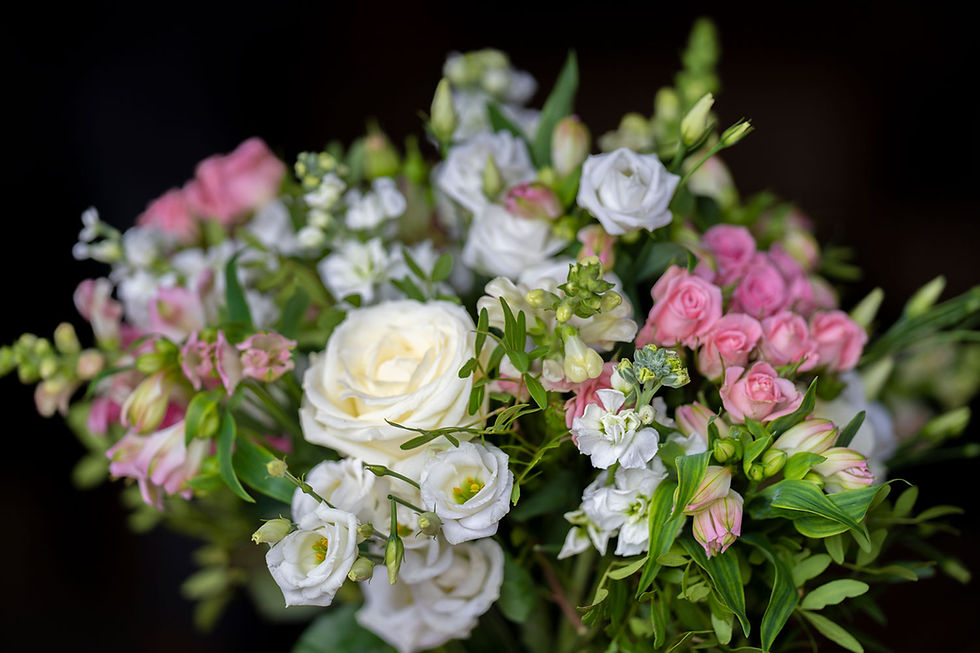 A bouquet of roses and other flowers in shades of pink and white.
