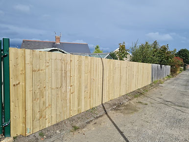 Long run of newly installed vertical timber panel fencing enclosing a residential property border