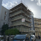Scaffolding surrounds a multi-story building under renovation