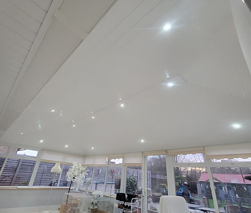 Spacious white conservatory with a sleek ceiling featuring recessed LED lights